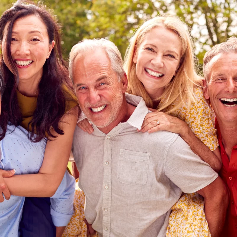 A group of older friends laughing together outdoors