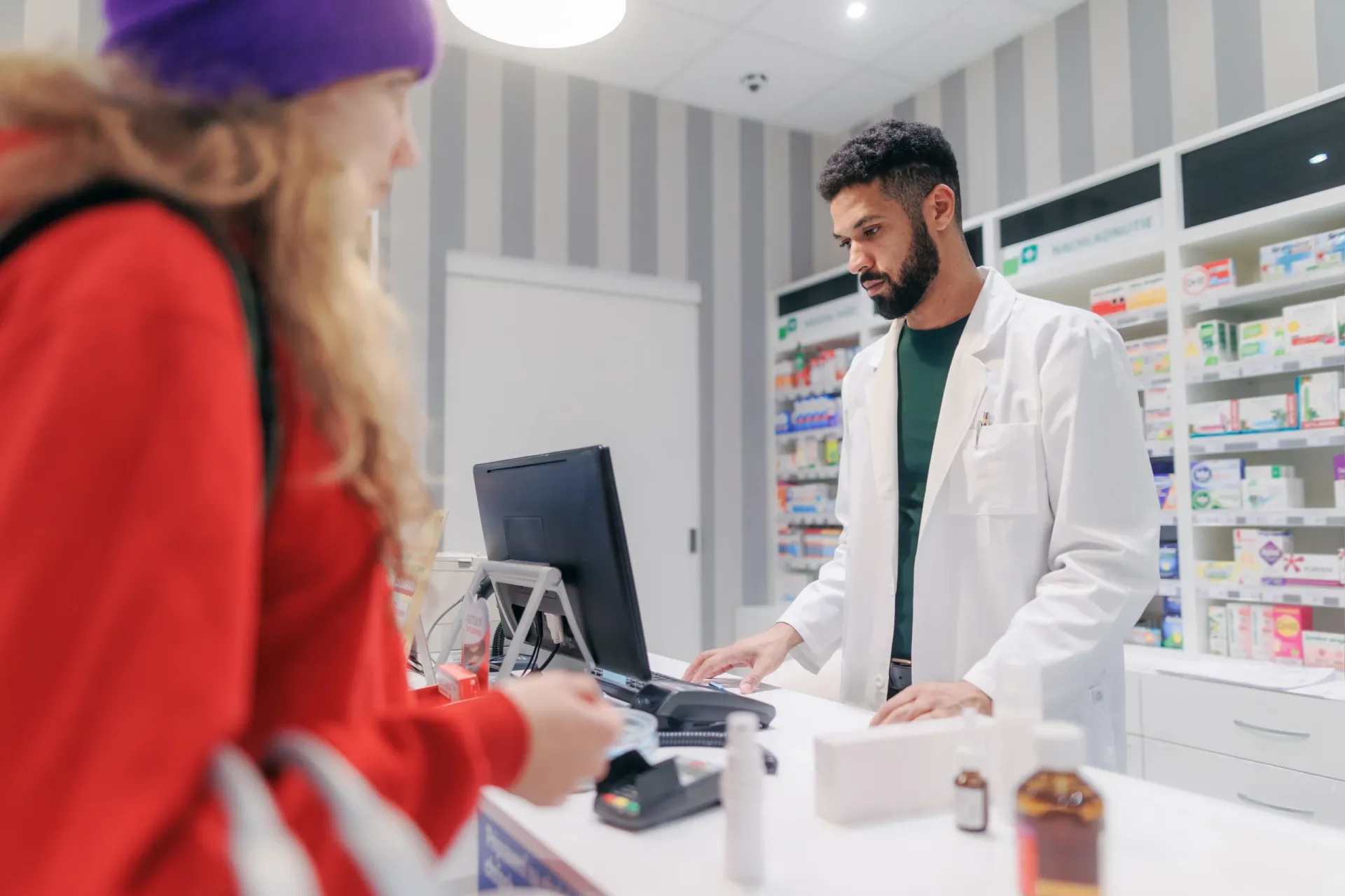 A pharmacist selling medication to a young patient