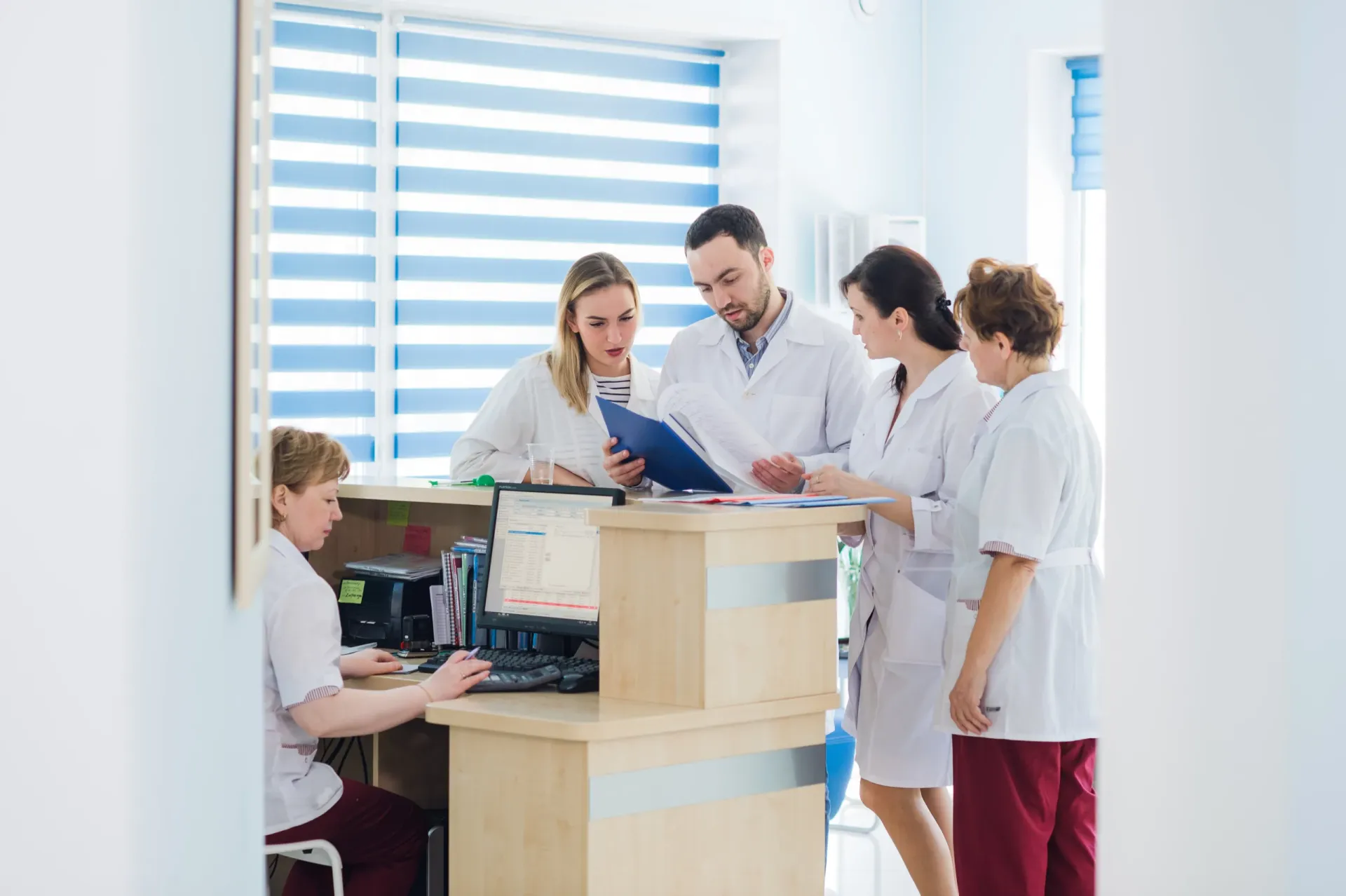 A doctor and receptionist at the reception desk of the practice