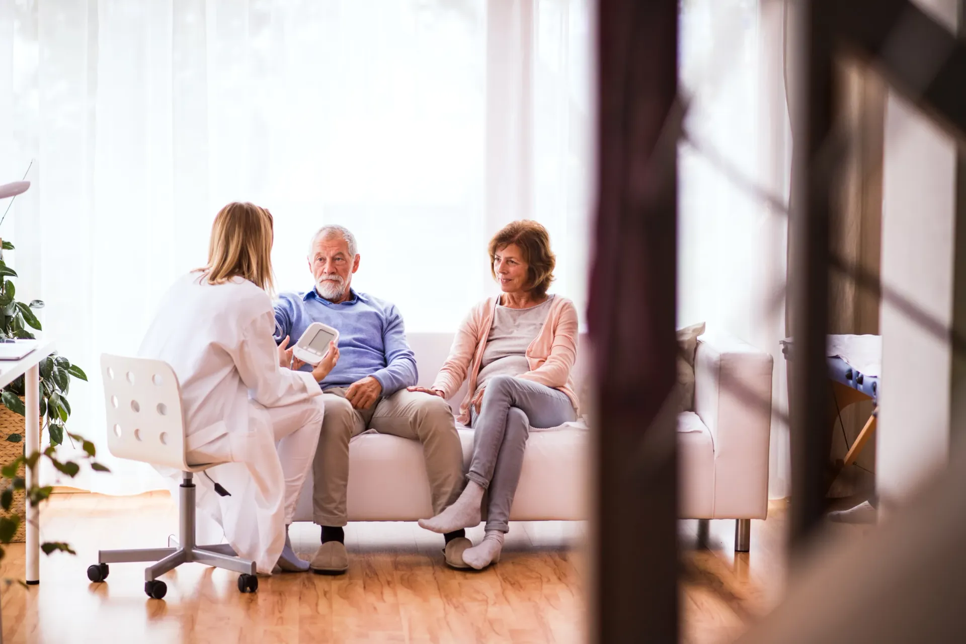 A doctor checking an older patient&rsquo;s blood pressure during a consultation